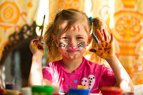 little girl with paint on her face and hands min young girl having fun with painting pictures on her face and hands